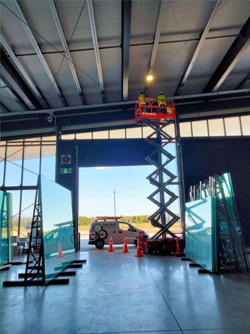 Trions Electrical team working at height on a scissor lift inside an industrial building.